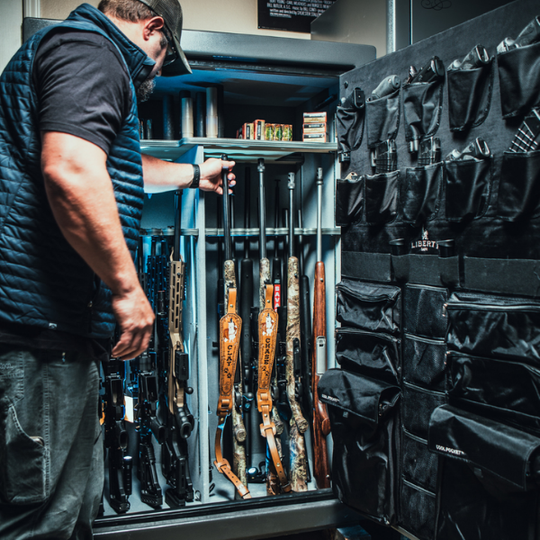 safe open with man looking at guns inside